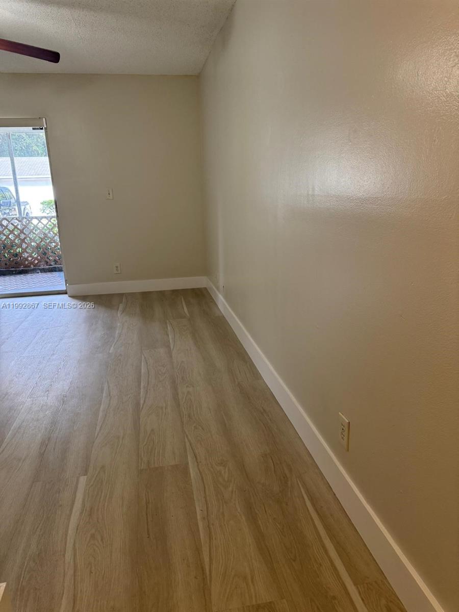 5760 Rock Island Road, Unit 304 Tamarac, FL 33319 - Photo 3 of 40 a view of a room with wooden floor and windows