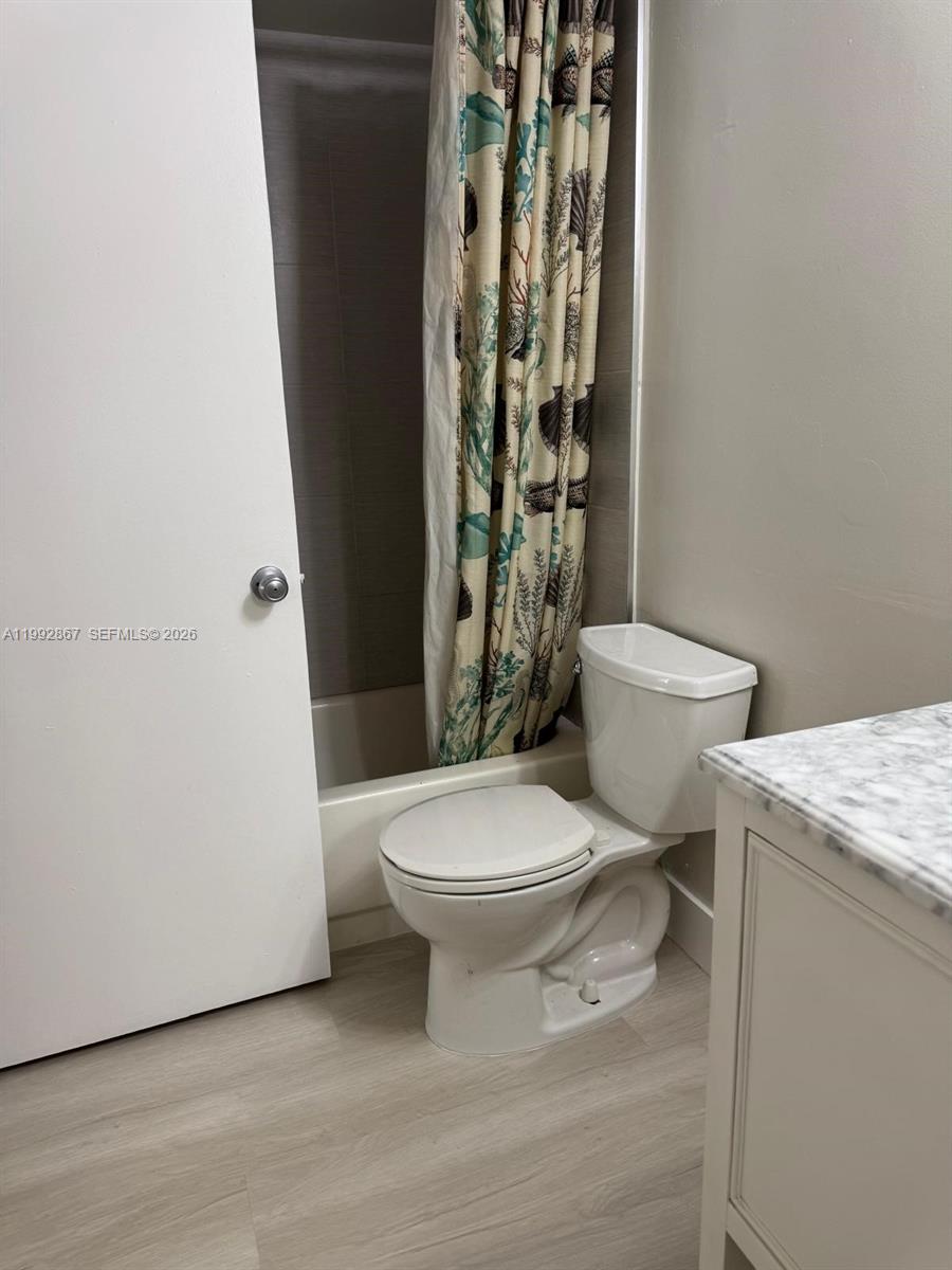 5760 Rock Island Road, Unit 304 Tamarac, FL 33319 - Photo 7 of 40 a white toilet sitting next to a shower curtain