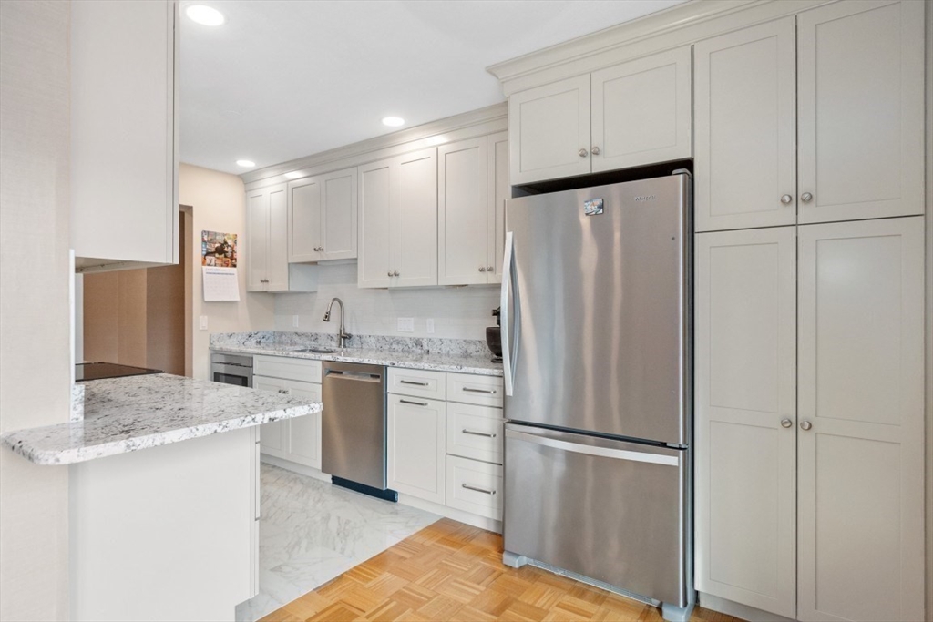 1202 Greendale Avenue, Unit 133 Needham, MA 02492 - Photo 15 of 25 a kitchen with a refrigerator sink and cabinets