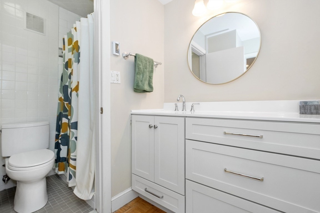 1202 Greendale Avenue, Unit 133 Needham, MA 02492 - Photo 20 of 25 a bathroom with a toilet a sink and a mirror