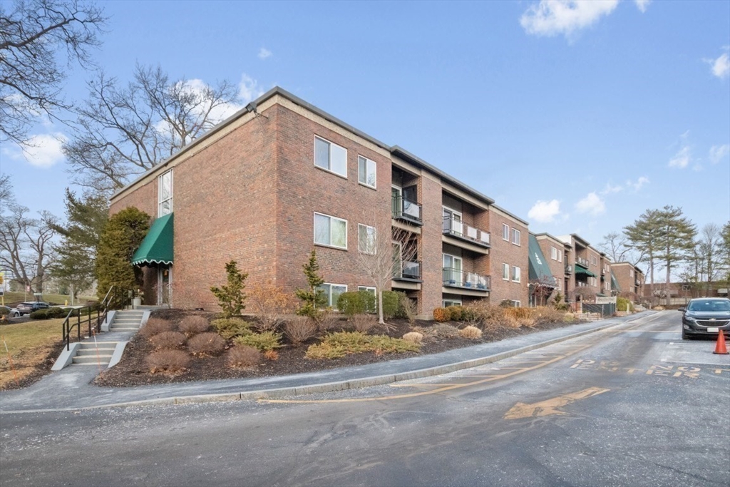 1202 Greendale Avenue, Unit 133 Needham, MA 02492 - Photo 22 of 25 a city view with tall buildings and cars parked on the roadside