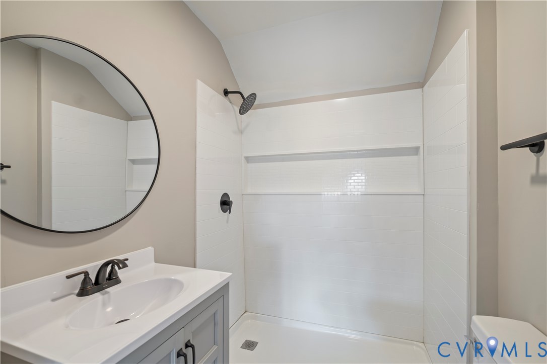 22 Corling Street Petersburg, VA 23803 - Photo 8 of 16 Bathroom with vanity, tiled shower, and vaulted ce