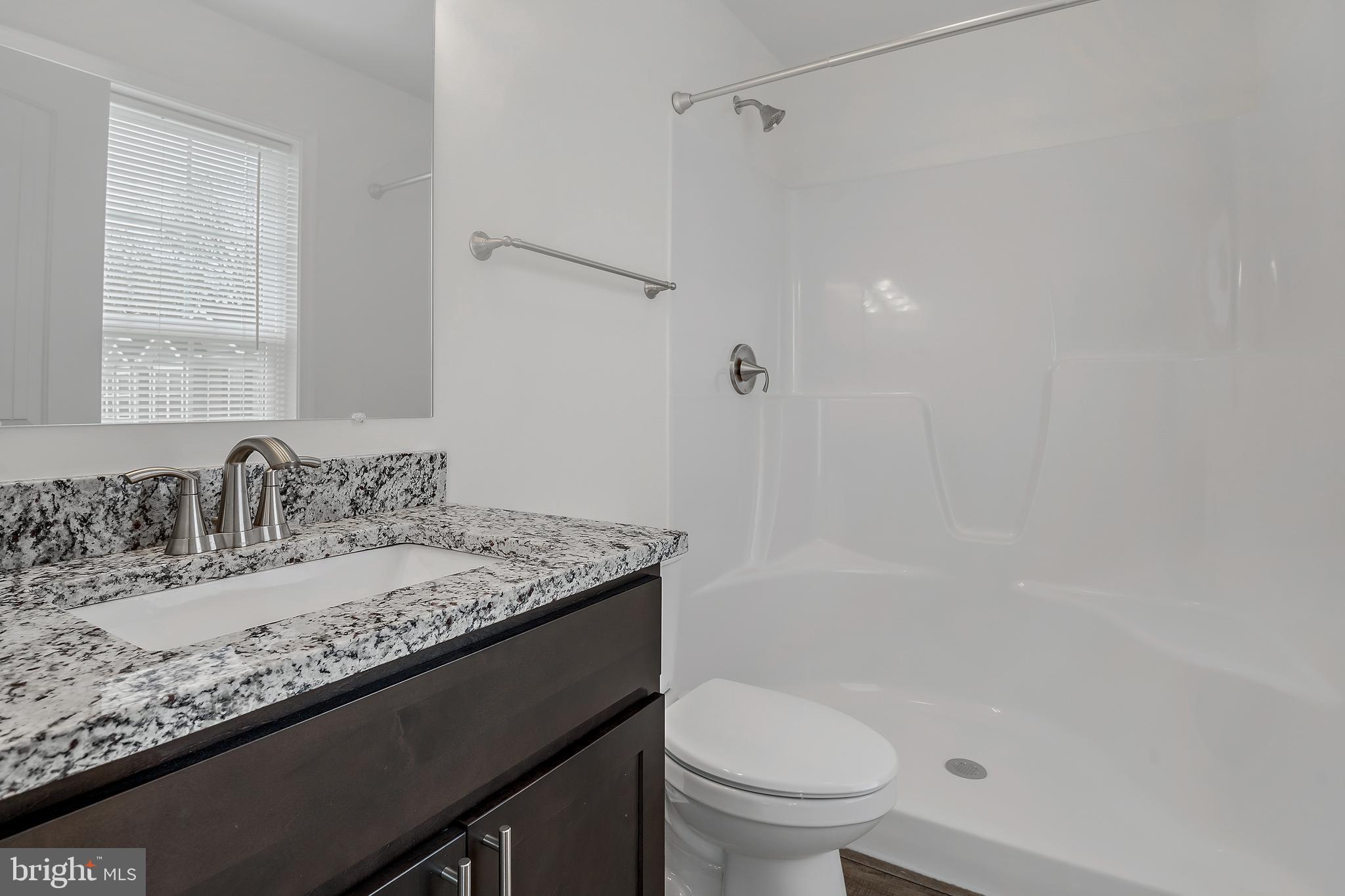 0 H Street, Unit 17 Carlisle, PA 17013 - Photo 11 of 19 a bathroom with a granite countertop sink a toilet and shower