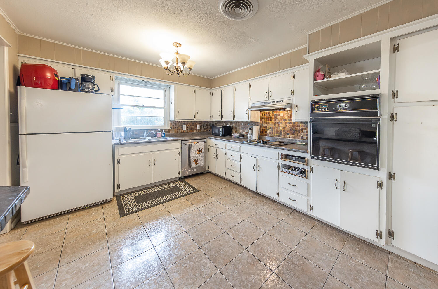 4604 31st Street Lubbock, TX 79410 - Photo 11 of 25 a kitchen with granite countertop a refrigerator and a stove top oven
