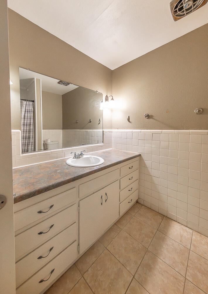 4604 31st Street Lubbock, TX 79410 - Photo 13 of 25 a bathroom with a granite countertop sink mirror and