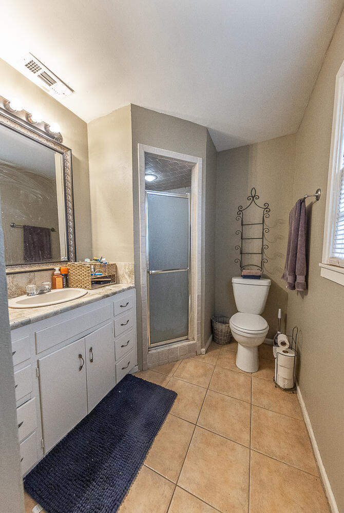 4604 31st Street Lubbock, TX 79410 - Photo 20 of 25 a bathroom with a toilet sink and mirror