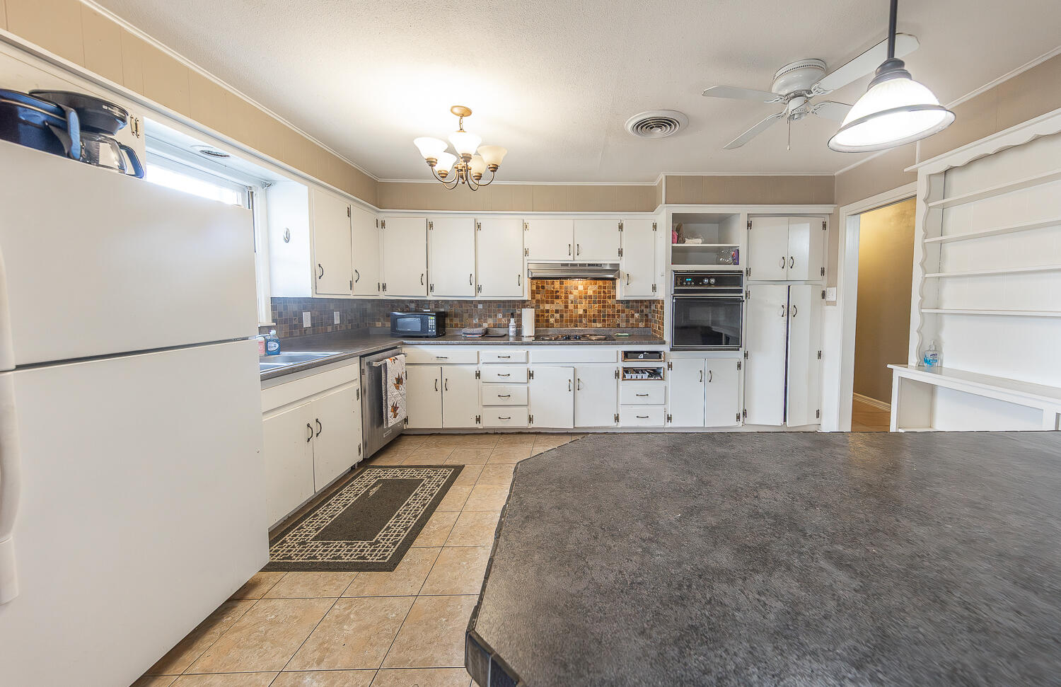 4604 31st Street Lubbock, TX 79410 - Photo 8 of 25 a large white kitchen with cabinets and a refrigerator