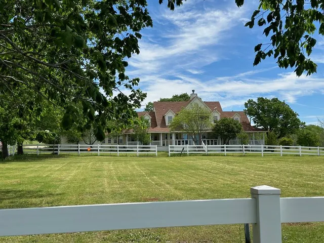 a view of a swimming pool with lawn chairs and plants