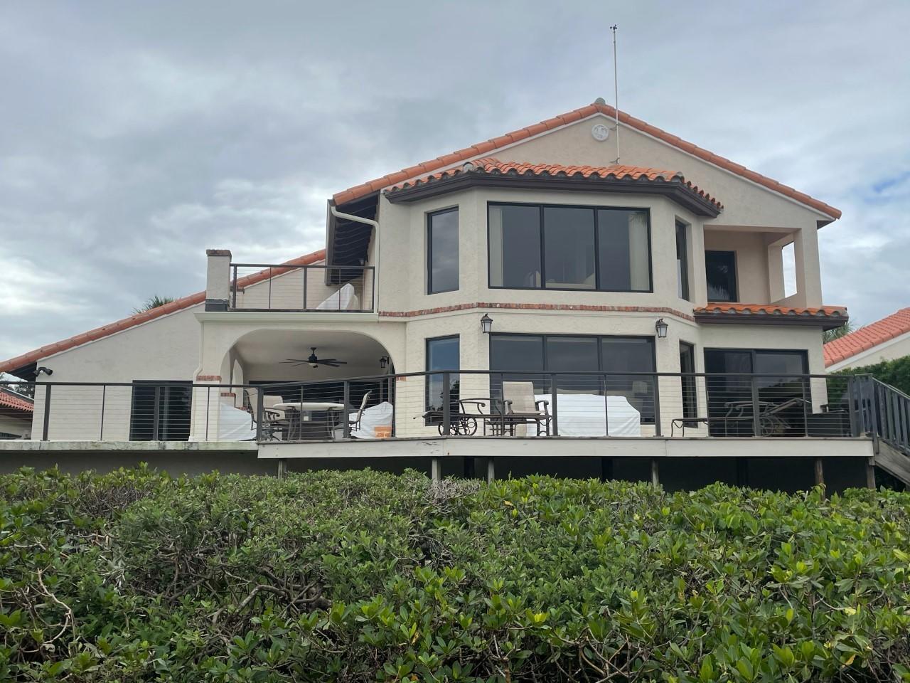 16952 Passage South Jupiter, FL 33477 - Photo 2 of 4 a front view of a house with a yard and potted plants