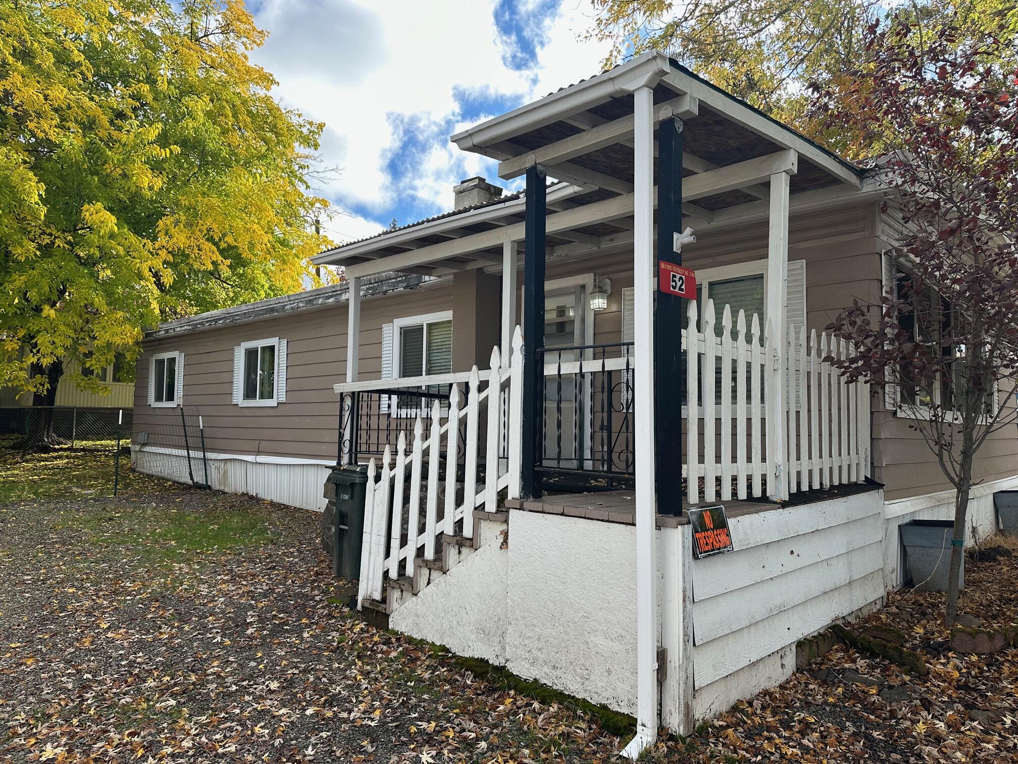 421 Stevens Road, Unit 52 Eagle Point, OR 97524 - Photo 2 of 18 a view of a house with a small yard and wooden fence