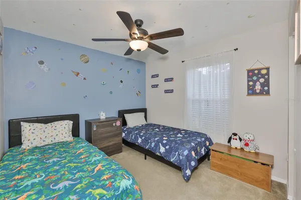 a bedroom with two beds and painting on the wall