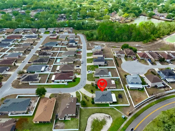 an aerial view of residential houses with outdoor space and lake view
