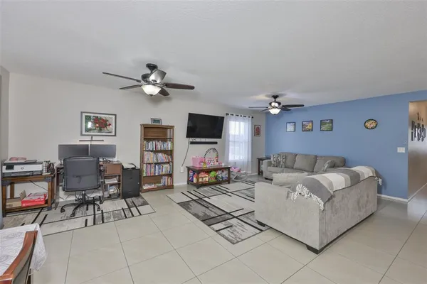 a living room with furniture and a ceiling fan