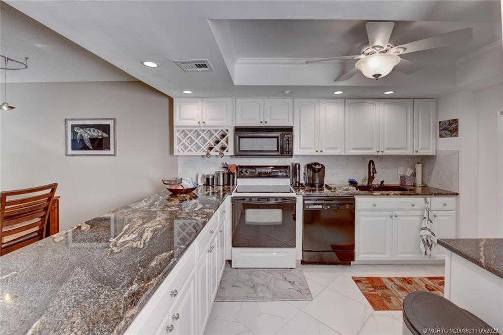3100 Southeast Pruitt Road, Unit B102 Port St. Lucie, FL 34952 - Photo 11 of 55 a large kitchen with stainless steel appliances granite countertop a sink and cabinets