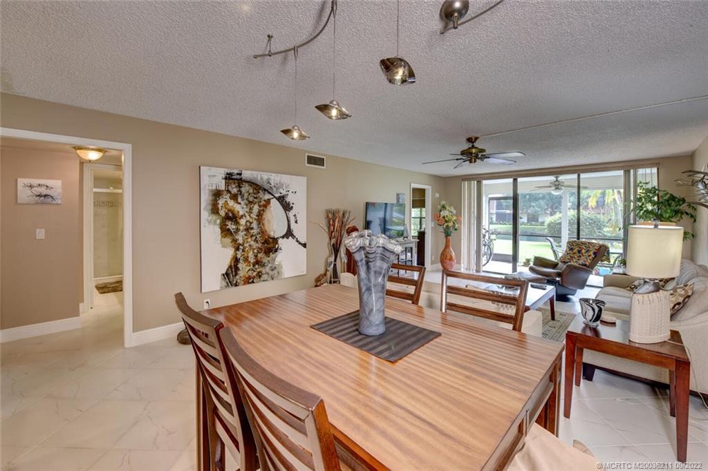 3100 Southeast Pruitt Road, Unit B102 Port St. Lucie, FL 34952 - Photo 16 of 55 a living room with furniture a rug potted plant and a large window