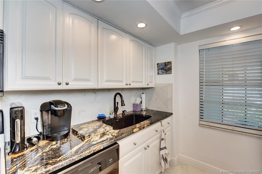 3100 Southeast Pruitt Road, Unit B102 Port St. Lucie, FL 34952 - Photo 18 of 55 a kitchen with stainless steel appliances granite countertop a sink and cabinets