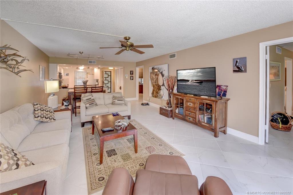 3100 Southeast Pruitt Road, Unit B102 Port St. Lucie, FL 34952 - Photo 21 of 55 a living room with furniture and a flat screen tv