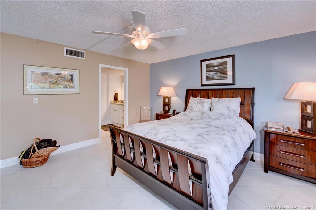 3100 Southeast Pruitt Road, Unit B102 Port St. Lucie, FL 34952 - Photo 25 of 55 a bed room with a bed and a chandelier