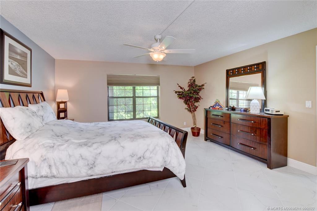 3100 Southeast Pruitt Road, Unit B102 Port St. Lucie, FL 34952 - Photo 26 of 55 a bed room with a bed and a chandelier