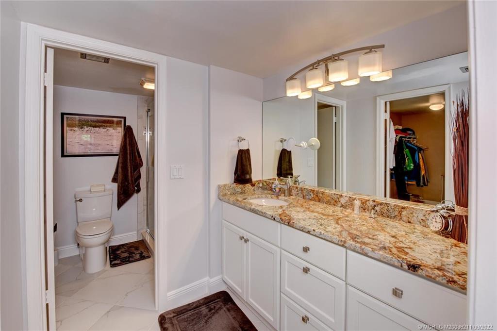 3100 Southeast Pruitt Road, Unit B102 Port St. Lucie, FL 34952 - Photo 27 of 55 a bathroom with a granite countertop sink vanity mirror and toilet
