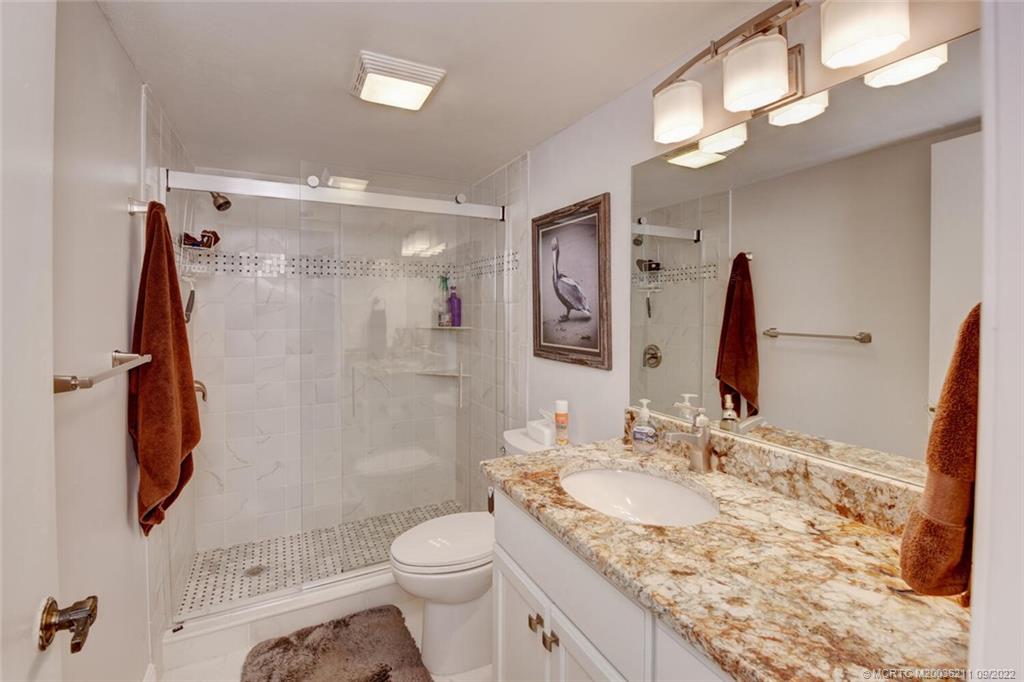 3100 Southeast Pruitt Road, Unit B102 Port St. Lucie, FL 34952 - Photo 32 of 55 a bathroom with a granite countertop sink toilet and shower