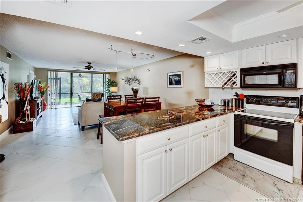 3100 Southeast Pruitt Road, Unit B102 Port St. Lucie, FL 34952 - Photo 7 of 55 a kitchen with stainless steel appliances granite countertop a stove and cabinets