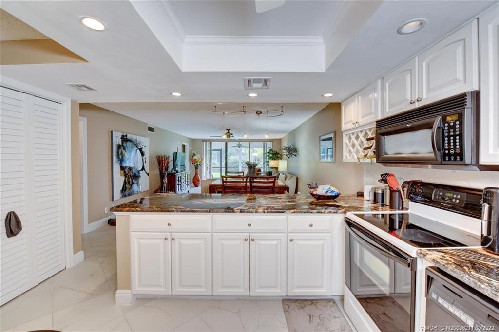 3100 Southeast Pruitt Road, Unit B102 Port St. Lucie, FL 34952 - Photo 8 of 55 a kitchen with white cabinets and appliances