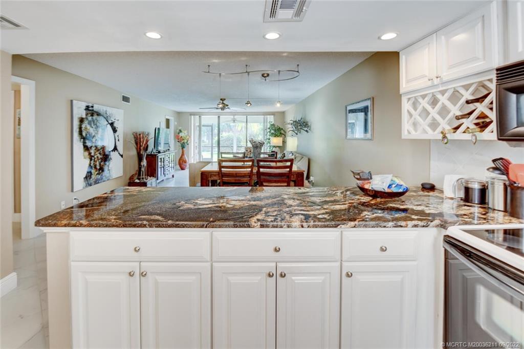 3100 Southeast Pruitt Road, Unit B102 Port St. Lucie, FL 34952 - Photo 9 of 55 a kitchen with stainless steel appliances granite countertop a sink and cabinets