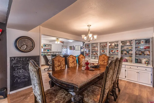 a view of a dining room with furniture a kitchen and chandelier