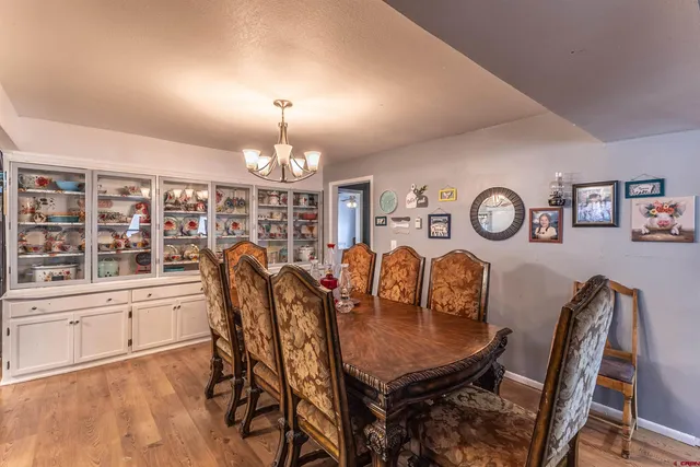 a kitchen with stainless steel appliances granite countertop a dining table chairs and a refrigerator
