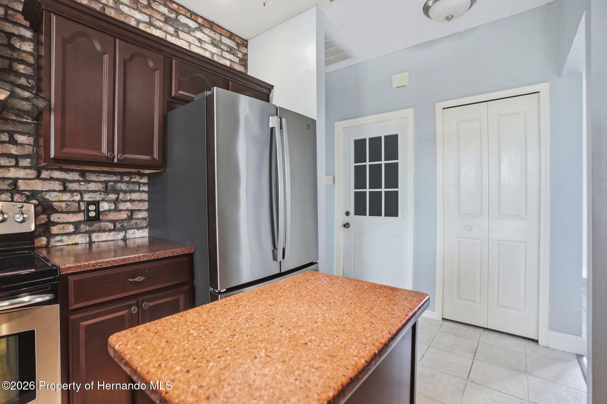 18131 Rivard Boulevard Brooksville, FL 34604 - Photo 15 of 66 a kitchen with stainless steel appliances granite countertop a refrigerator and a stove top oven