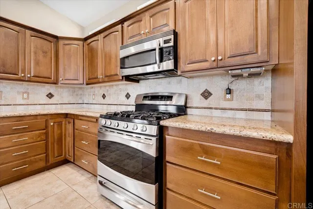 a kitchen with stainless steel appliances granite countertop a stove microwave and cabinets