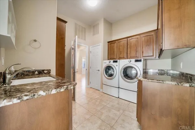 a utility room with sink dryer and washer