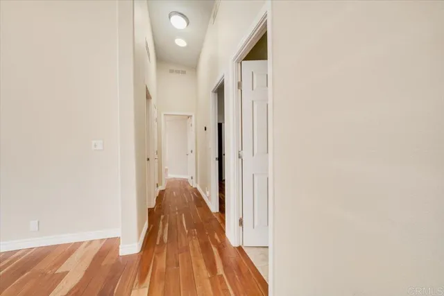 a view of a room with wooden floor and a bathroom