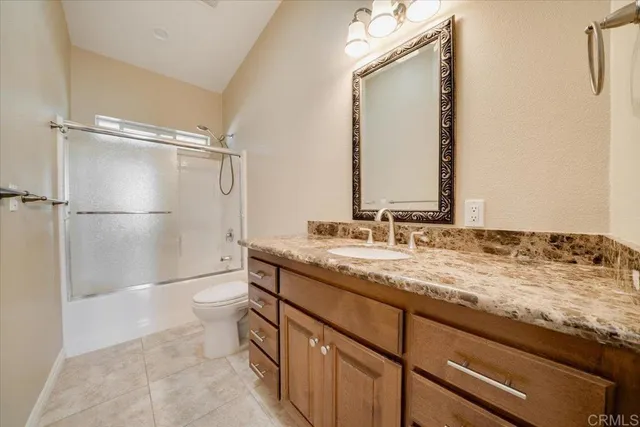 a bathroom with a granite countertop sink mirror and a shower