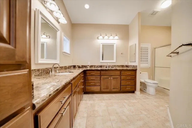 a spacious bathroom with a granite countertop sink and a bathtub