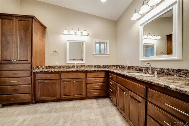 a spacious bathroom with a granite countertop sink and a mirror