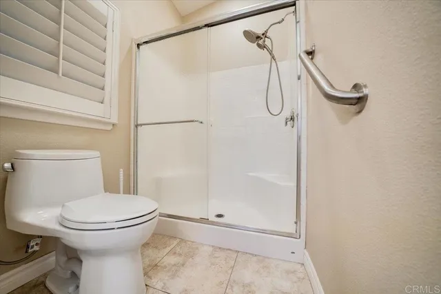 a bathroom with a toilet and a shower