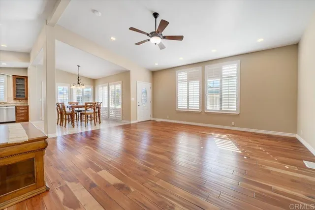 a view of a livingroom with furniture wooden floor and a ceiling fan