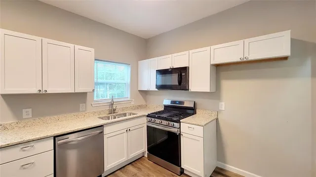 a kitchen with white cabinets stainless steel appliances and sink
