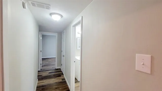 a view of a hallway with wooden floor and entryway
