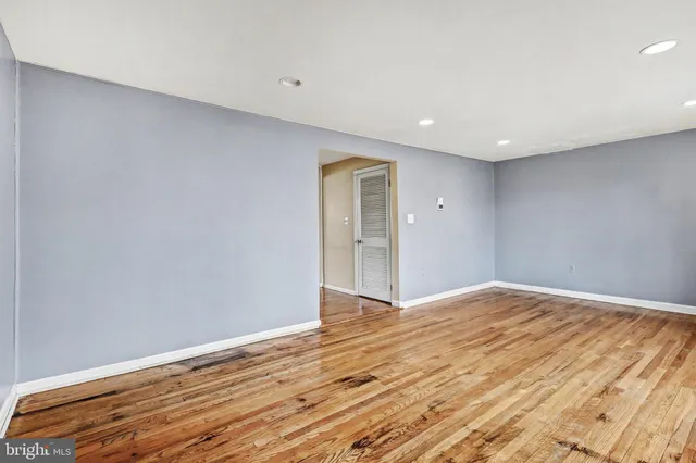 a view of an empty room with wooden floor and closet
