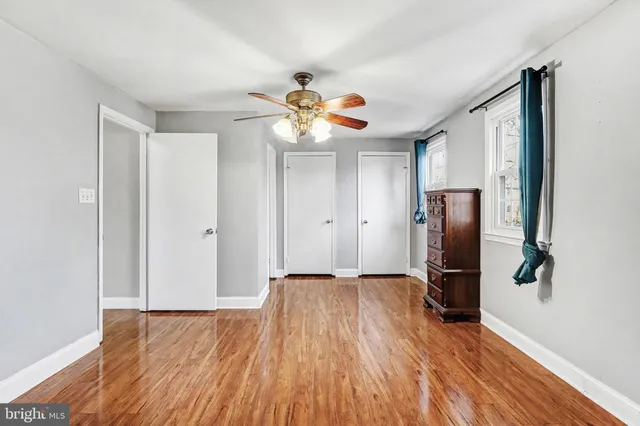 a view of a livingroom with a ceiling fan wooden floor and a chandelier fan
