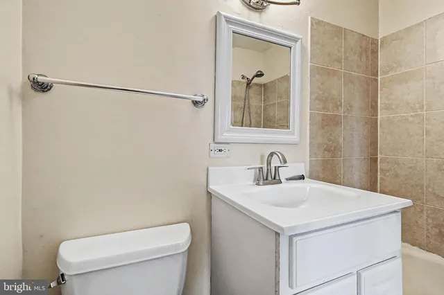 a bathroom with a toilet sink vanity and mirror