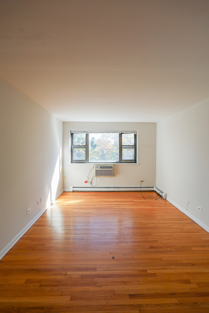 606 West Cornelia Avenue, Unit 482 Chicago, IL 60657 - Photo 2 of 13 a view of empty room with wooden floor and fan