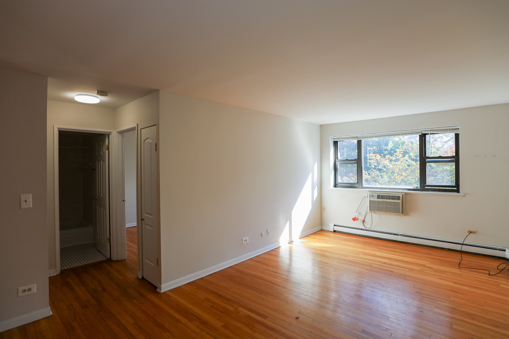 606 West Cornelia Avenue, Unit 482 Chicago, IL 60657 - Photo 3 of 13 an empty room with wooden floor and windows