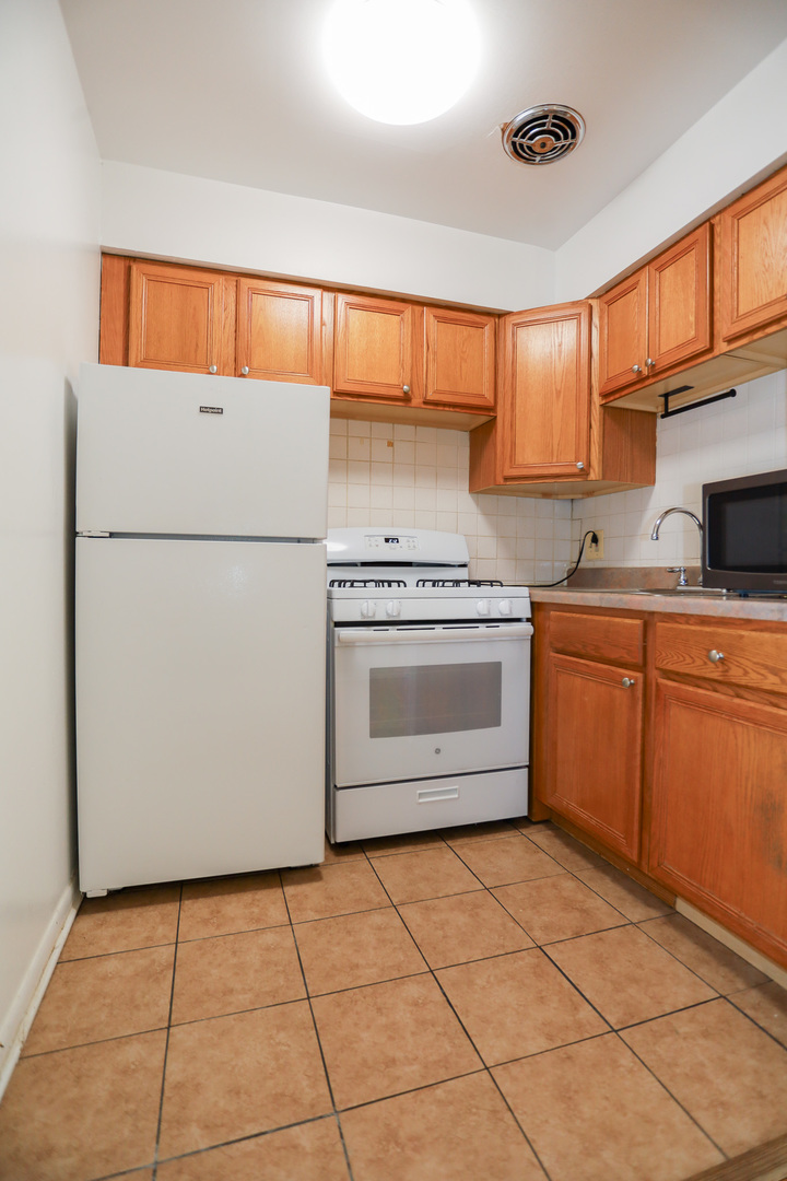 606 West Cornelia Avenue, Unit 482 Chicago, IL 60657 - Photo 6 of 13 a kitchen with a stove a sink and a refrigerator