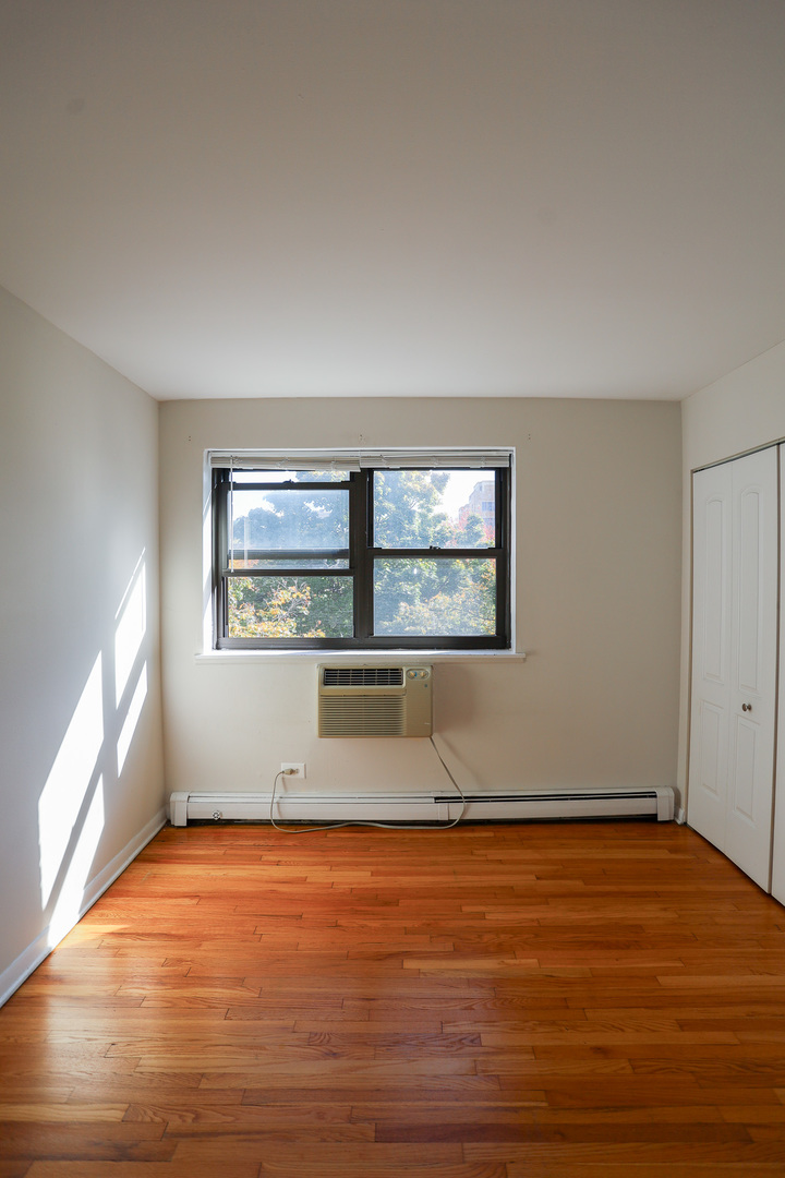 606 West Cornelia Avenue, Unit 482 Chicago, IL 60657 - Photo 8 of 13 an empty room with wooden floor and windows