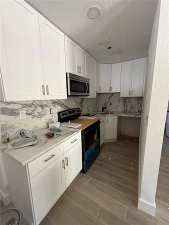 a kitchen with a sink stove and microwave