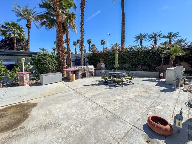 a view of a patio with a table and chairs under an umbrella
